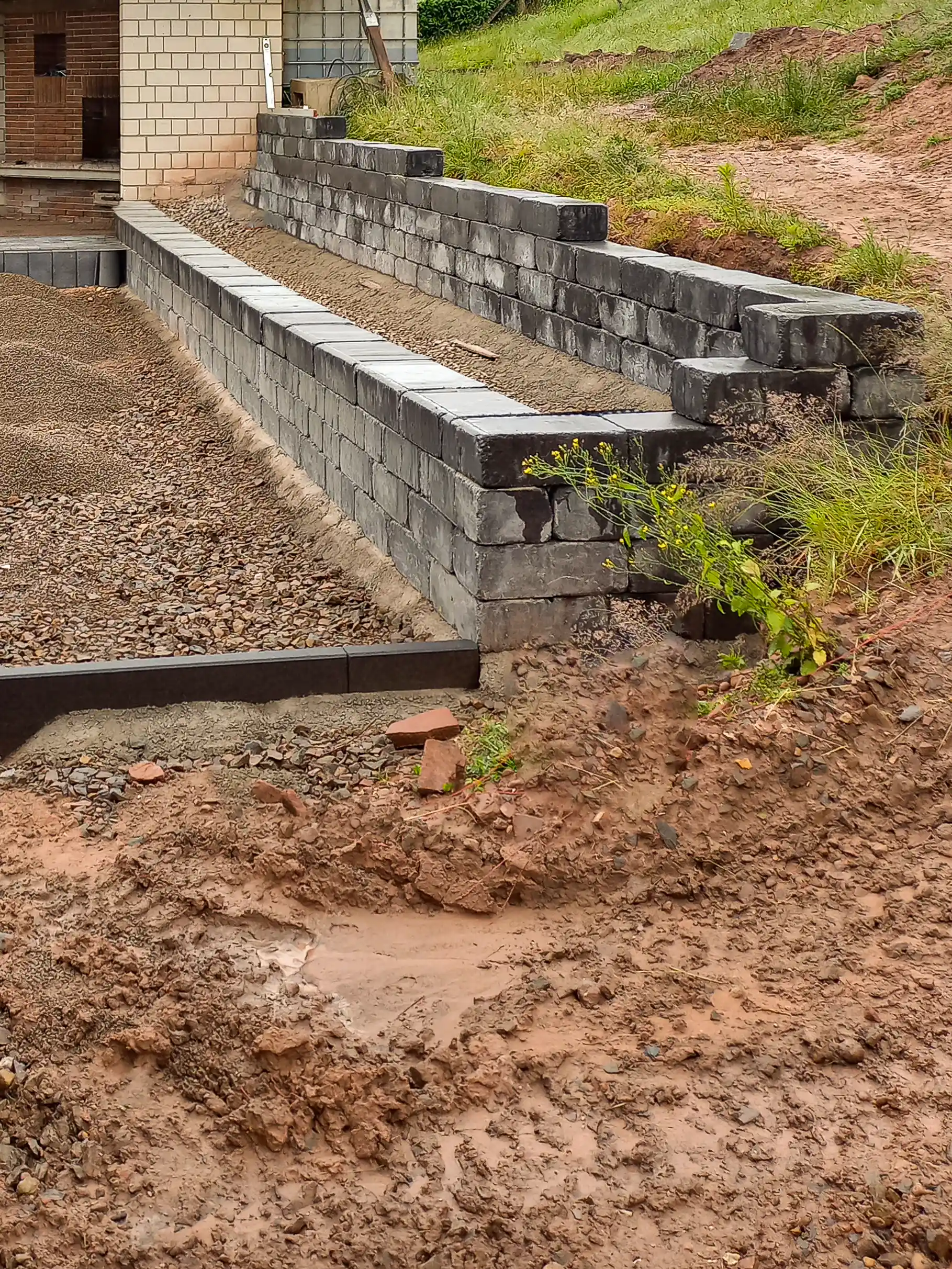 Bau einer Gartenmauer zur Hangbefestigung aus dunklen Mauersteinen in Rotenburg an der Fulda - durch André Franz Bau