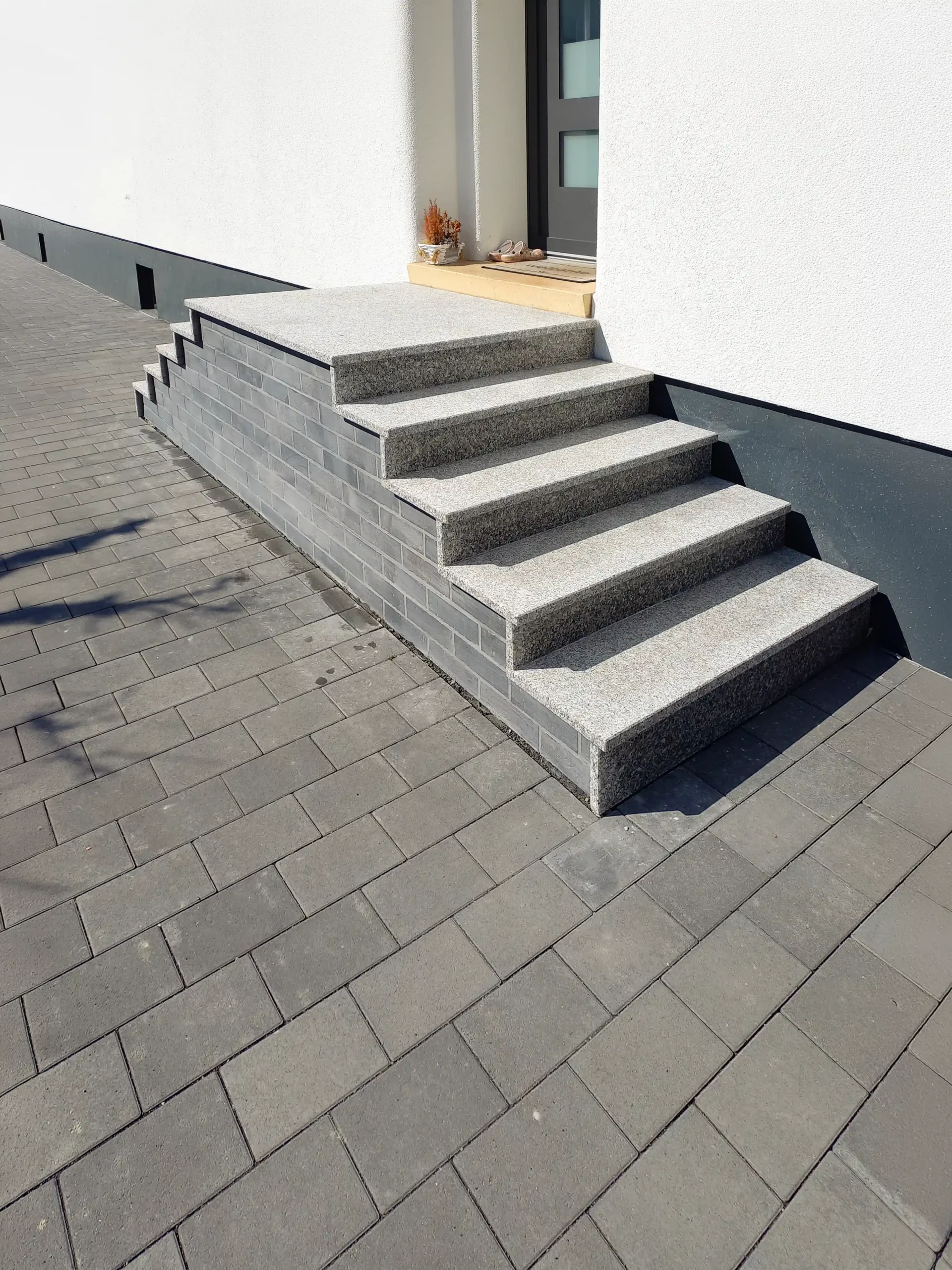 treppenverkleidung_bebra_gilfershausen Treppenverkleidung im Eingangsbereich mit Granitstufen und dunklen Riemchen in Bebra-Gilfershausen - durch André Franz Bau